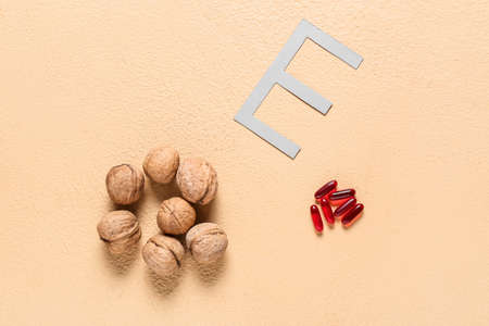 Letter E with walnuts and pills on color backgroundの写真素材
