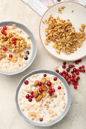 Tasty granola with milk on light background