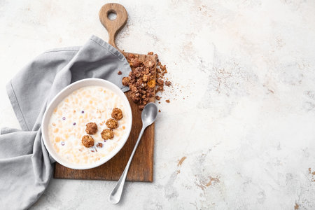 Tasty granola with milk on light backgroundの写真素材