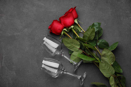 Beautiful red roses and glasses on dark backgroundの写真素材