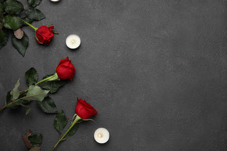 Beautiful red roses and burning candles on dark backgroundの写真素材