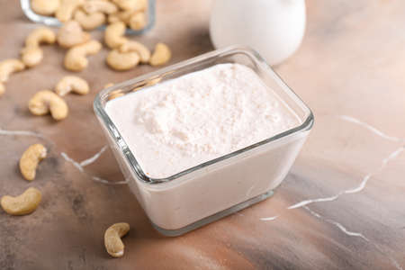 Bowl with cashew sour cream and nuts on grunge background, closeupの写真素材