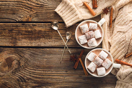 Composition with cups of hot cocoa drink, marshmallows and cinnamon on wooden backgroundの写真素材