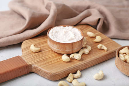Bowl with cashew sour cream and nuts on light backgroundの写真素材