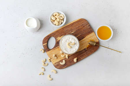 Composition with cashew sour cream, nuts and honey on light backgroundの写真素材