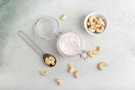 Jar with cashew sour cream and nuts on light backgroundの写真素材