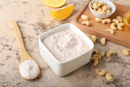 Bowl with cashew sour cream, nuts and lemon on grunge backgroundの写真素材