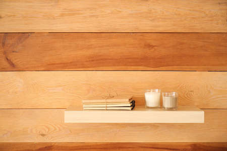 Aroma candles with books on shelf in roomの写真素材