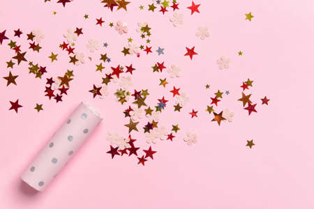Party popper and confetti on color backgroundの写真素材