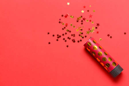 Party popper and confetti on color backgroundの写真素材