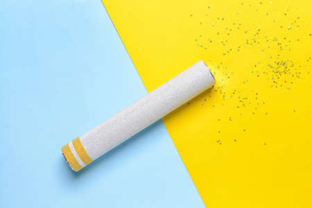 Party popper and confetti on color backgroundの写真素材