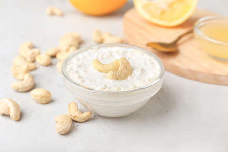 Bowl with cashew sour cream, nuts and lemon juice on light background, closeupの写真素材