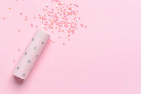 Party popper and confetti on color backgroundの写真素材