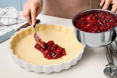 Woman cooking berry pie in kitchenの写真素材