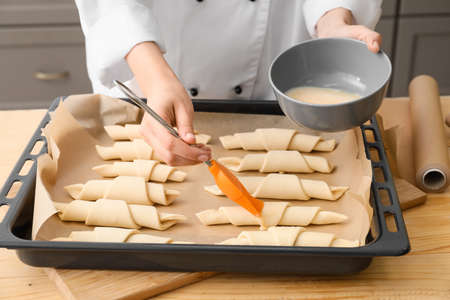 Woman cooking croissants in kitchen, closeup