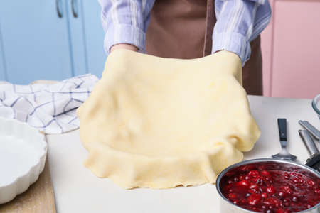 Woman cooking berry pie in kitchenの写真素材