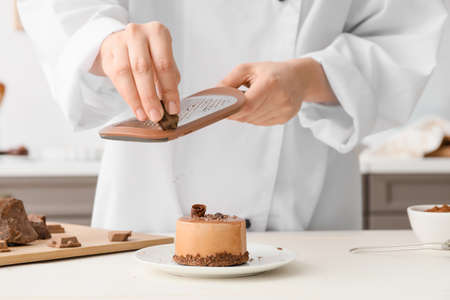Woman cooking tasty cake in kitchenの写真素材