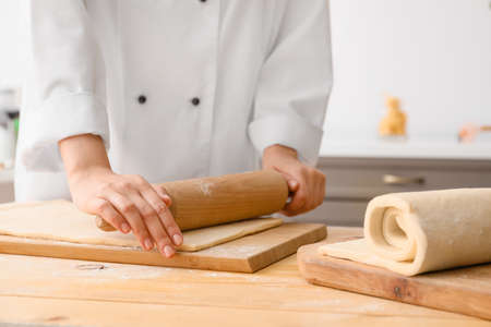 Woman making dough in kitchen