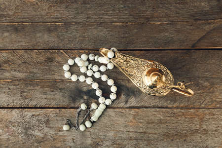 Aladdin lamp of wishes and tasbih on wooden backgroundの写真素材