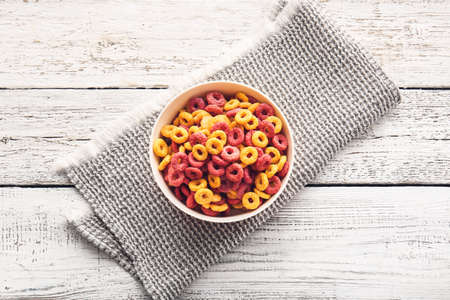 Bowl of colorful cereal rings on light wooden backgroundの写真素材