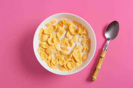 Bowl with tasty cornflakes on color backgroundの写真素材
