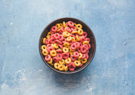 Bowl of colorful cereal rings on color backgroundの写真素材