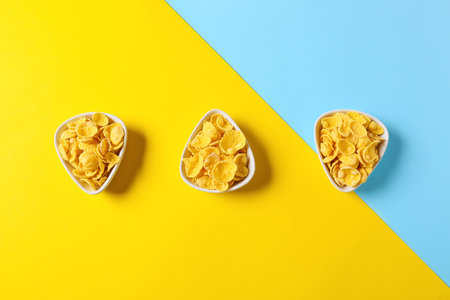Bowls with tasty cornflakes on color backgroundの写真素材