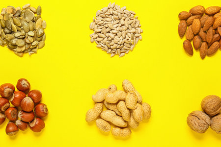Different healthy nuts and seeds on color backgroundの写真素材