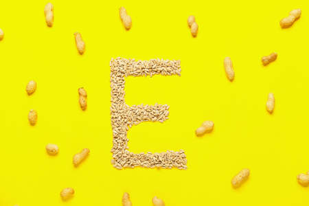 Letter E made of healthy sunflower seeds and peanut nuts on color backgroundの写真素材