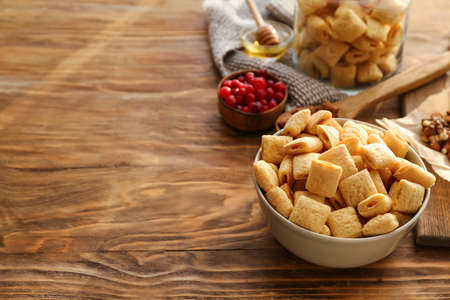 Bowl with tasty corn pillows on wooden backgroundの写真素材