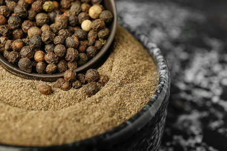 Bowls with black peppercorns and powder on dark background, closeupの写真素材