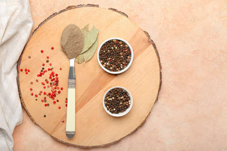 Bowls with black peppercorns and spoon of powder on color backgroundの写真素材