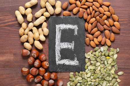 Letter E with healthy nuts and seeds on wooden backgroundの写真素材