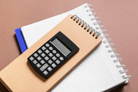 Modern calculator with notebooks on color backgroundの写真素材