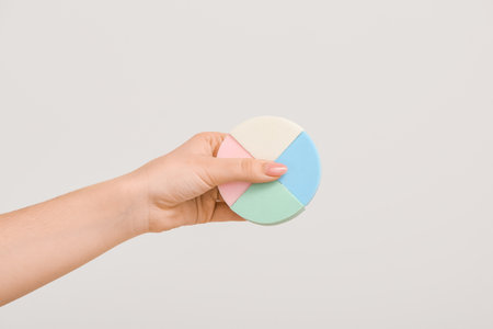 Female hand with stylish makeup sponges on light backgroundの写真素材