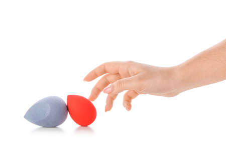 Female hand with stylish makeup sponges on white backgroundの写真素材