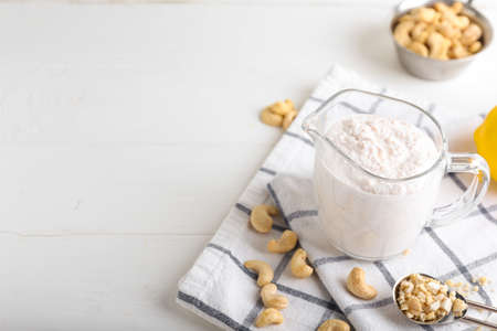 Jug of sour cream with cashew nuts on light backgroundの写真素材