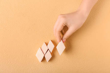 Female hand with stylish makeup sponges on color backgroundの写真素材