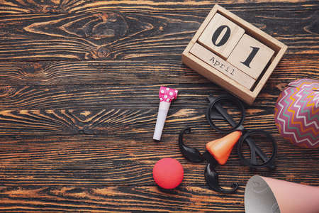 Party decor and calendar with date of April Fools Day on wooden backgroundの写真素材