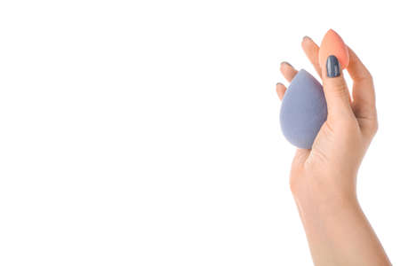 Female hand with stylish makeup sponge on white backgroundの写真素材