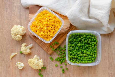 Plastic containers with vegetables on wooden backgroundの写真素材