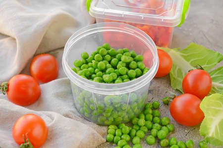 Plastic containers with vegetables on gray background, closeupの写真素材