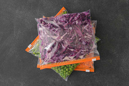 Plastic bags with vegetables on dark background