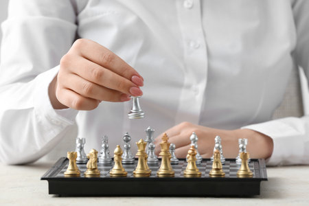 Woman playing chess on light tableの写真素材