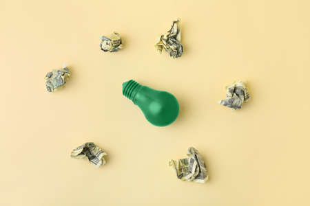 Light bulb with crumpled dollar banknotes on color background. Concept of business ideaの写真素材