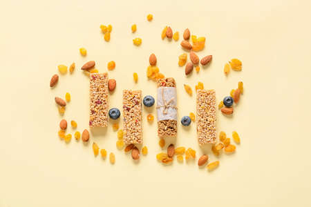 Healthy cereal bars, berries and nuts on color backgroundの写真素材
