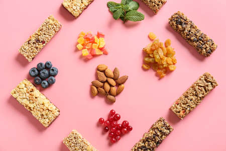 Composition with healthy cereal bars, berries and nuts on color background