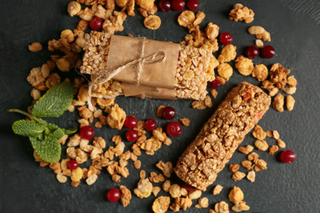 Healthy cereal bars and cranberries on dark backgroundの写真素材