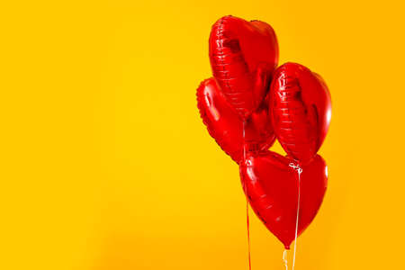 Heart shaped air balloons on color backgroundの写真素材