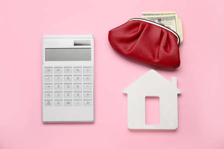 Calculator with model of house, wallet and money on color backgroundの写真素材